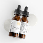 Two brown glass bottles with black droppers on a white background